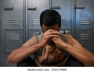 An unidentified young man leans his head in his hands, depressed on campus - Powered by Shutterstock