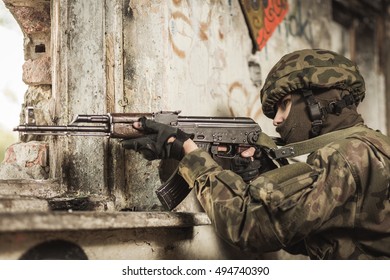 Unifomed soldier on a training ground pointing his gun 