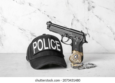 Uniform Of Policeman With Gun And Badge On Light Background