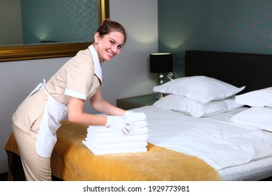 Uniformed Maid Wearing White Cotton Gloves Changes Towels In The Hotel Room. Friendly Hotel Staff. The Concept Of The Hotel Business. Photos In The Interior.