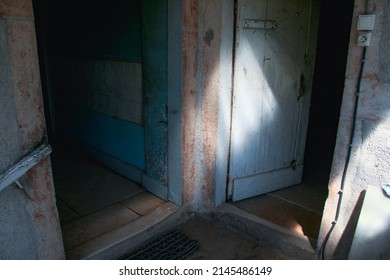 In an uninhabited and abandoned house in Burgundy (France) a ray of sunlight illuminates old doors whose paint is peeling. - Shutterstock ID 2145486149