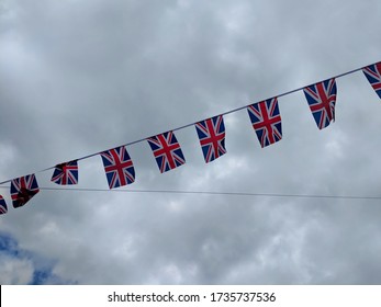 Union Jack Bunting Fluttering Against A Blue Cloudy Sky Celebrating The 75th Anniversary Of VE Day (Victory In Europe Day) Marking The End Of World War II 