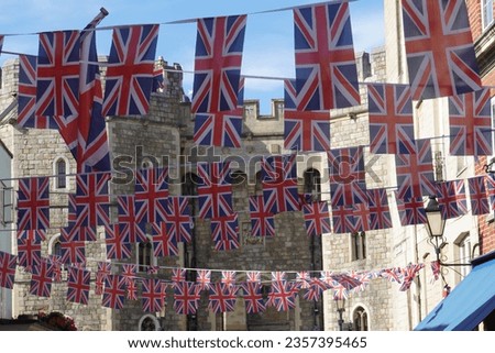 Union Jack bunting hanging in a street in front of Windsor Castle in Berkshire United Kingdom. Celebrating the inauguration of King Charles.