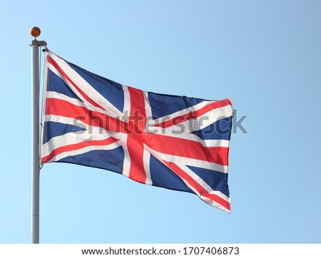 Union Jack flag blowing in the wind on flag pole