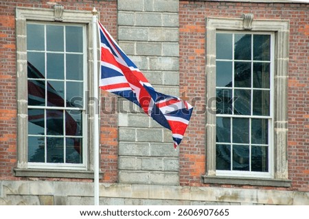 Union Jack Flag Flutters Between Georgian Windows on Historic Building