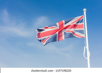 Union Jack Flag Flying From a Flagpole Under a Blue Sky