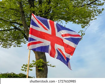 Union Jack Flag Flying On A Wooden Pole In A Garden