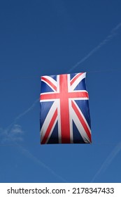 Union Jack Flag Hanging Over A Street Against A Deep Blue Sky. No People. Copy Space.