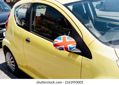 Union Jack flag on the private car side door mirror is coated with textil decor. Great Britain national flag colors. Festive Car Decor for Queen jubilee celebration. Patriotic concept.