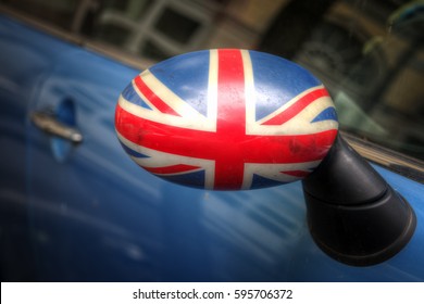 Union Jack flag painted on the rear-view mirror of a car parked in a public road. - Shutterstock ID 595706372