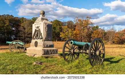 A Union monument and civil war cannons in the Wheatfield on the Gettysburg National Military Park on a sunny fall day