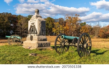 A Union monument and civil war cannons in the Wheatfield on the Gettysburg National Military Park on a sunny fall day