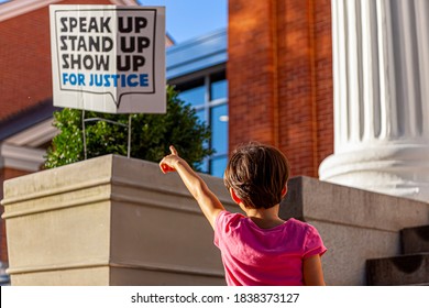 A Unique Abstract Image Where A Little Girl Is Pointing A Sign Post That Says Speak Up, Stand Up, Show Up For Justice. A Concept Image For Social Awareness, Equality, Human Rights, Non Discrimination.