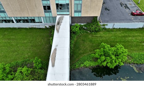 The unique adaptation of elements that act as a means of static transportation to connect two separate occupiable buildings for the means of implementing and progressing the societal development of students.