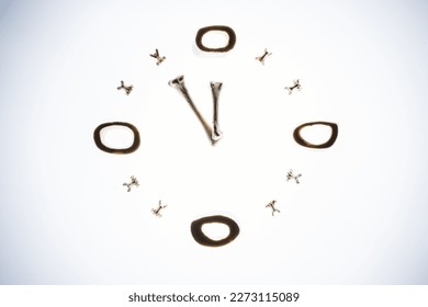 A unique analog clock made of bones, consisting of three interlocking rings with a central arrow pointing to the time of five minutes to twelve - Powered by Shutterstock - Get 15% off with code: PIKWIZARD15