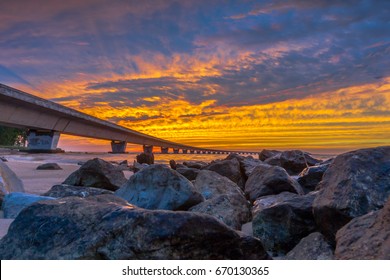 Unique angle of the Garcon Point Bridge spanning over Pensacola Bay shot during a gorgeous sunset from the Gulf Breeze, Florida side of the bridge