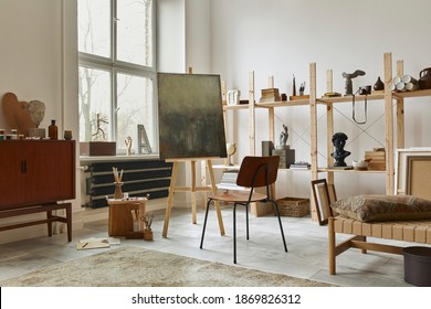 Unique artist workspace interior with stylish teak commode, wooden easel, bookcase, artworks, painting accessories, decoration and elegant personal stuff. Modern work room for artist. Template.  - Powered by Shutterstock