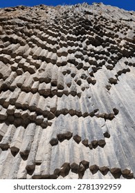 Unique basalt column formations at Symphony of Stones in Garni Gorge, Armenia. Natural volcanic rock pattern resembling organ pipes in a dramatic canyon landscape.