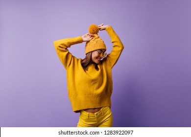 Unique, Charming Girl Shyly Posing On Purple Background. Portrait Of Model From Europe In Stylish Outfit