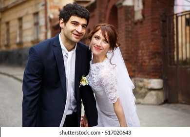 unique couple posing on old street