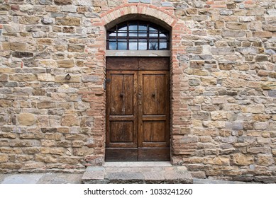Unique door in stone wall of medieval town in Tuscany, Italy. Doors in stone, entrances through the supporting walls.