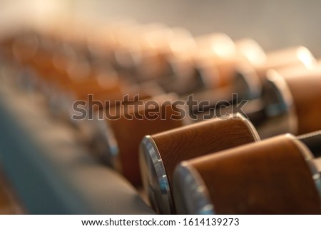 Unique edition. Stylish male dumbbells made of wood and steel lying in a row. Sports equipment, healthy lifestyle, sport. Horizontal shot. Selective focus. Copy space