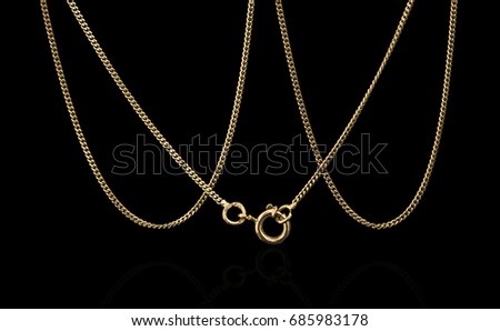 Unique gold necklace isolated on black background, macro closeup showing yellow chain links detail