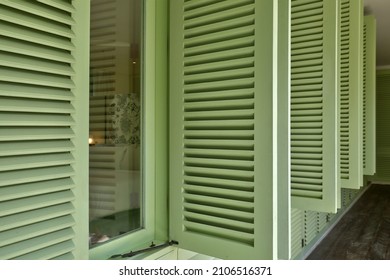 Unique green wooden shutters are opening