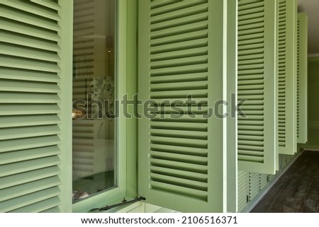 Unique green wooden shutters are opening