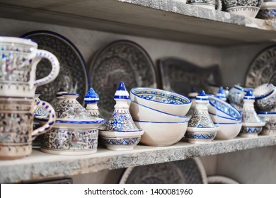 Unique handmade tracery oriental traditional pottery crockery made of natural clay painted and glazed on a market shelf set in a row diagonal perspective view close up - Powered by Shutterstock