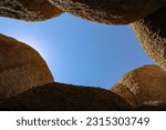 A unique look up to the sky through some large rock formations at Joshua Tree National Park.