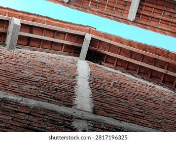 A unique low-angle view of bats hanging upside down beneath the roof tiles of a residential house. This wildlife image captures the natural roosting behavior of bats in an urban environment, highlighting their role in biodiversity, nocturnal ecosystems, and coexistence with humans.