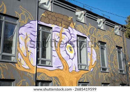 Unique mural featuring surreal tree design on building wall in an urban setting