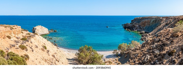 Unique panoramic view of secluded remote bay pebble beach at Mediterranean Makrigialos summer resort southeast coast Crete Greece. Blue sky, crystal clear turquoise waters. Travel destination concept