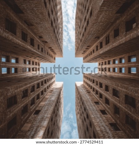 A unique perspective looking straight up between four tall, imposing buildings, creating a cross shape against a clear blue sky.
