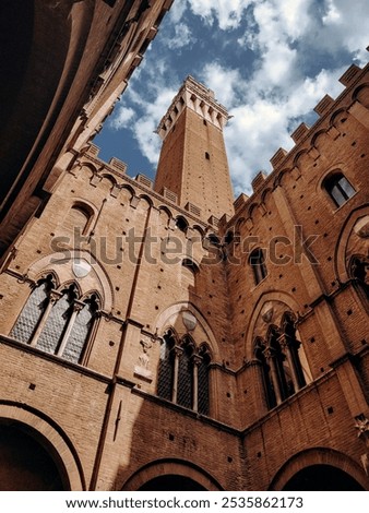 Unique perspective of the tower at Il Campo in Siena, Italy, captured from inside the building looking up. This dramatic view highlights historic architecture, perfect for travel and cultural projects