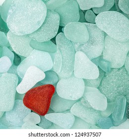 Unique red sea glass isolated on green sea glass background