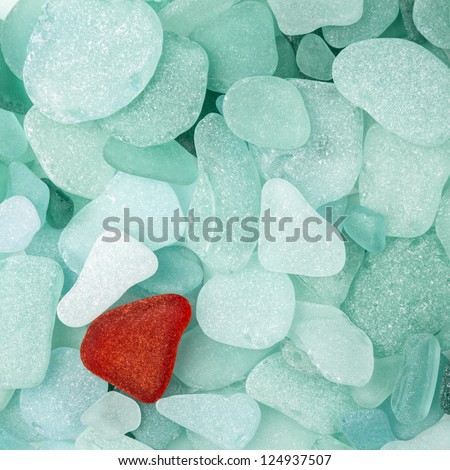 Unique red sea glass isolated on green sea glass background
