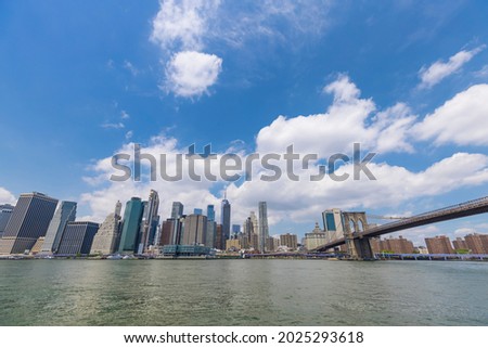 Unique shape summer clouds float over the Lower Manhattan skyscraper and Brooklyn Bridge along the East River on June 20, 2021 in the Brooklyn Borough of New York City NY USA.