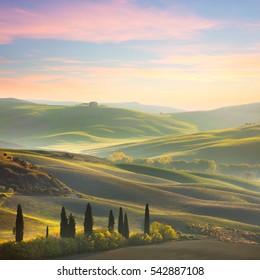 Unique Sundown tuscany landscape in spring time - wave hills, cypresses trees  and beautiful colors of sky. Tuscany, Italy, Europe