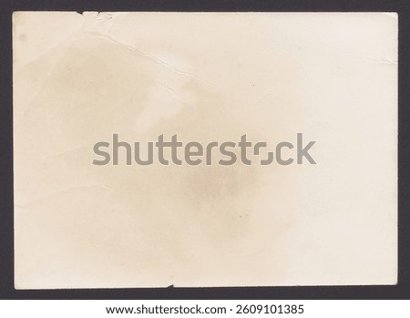 Unique texture of old paper with spots on a black background. Interesting old paper with straight edges. The noble beauty of natural antique darkened and yellowed paper from the 1960s-1970s.