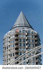 Unique tower building featuring a pointed roof and balconies.