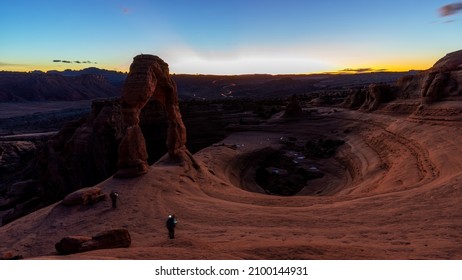 Unique View Of Utah’s Delicate Arch At Night With Car Lights Streaking In The Distance