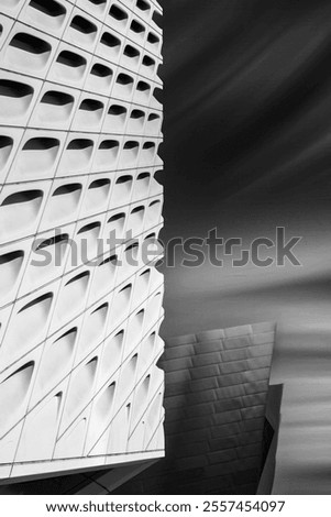 A uniquely patterned building facade shows sleek lines and curves in futuristic architecture style.