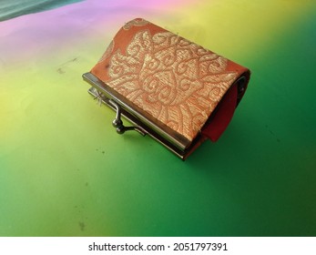 a uniquely shaped wallet belonging to a beautiful woman