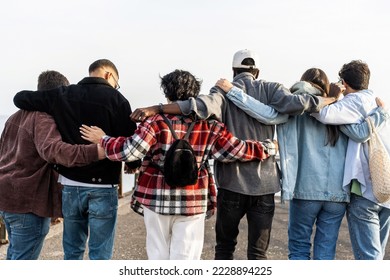 Unite group of multiethnic young friends walking outdoors hugging together - unity, oneness, youth hipster culture, solidarity, equality and international teamwork concept - Powered by Shutterstock