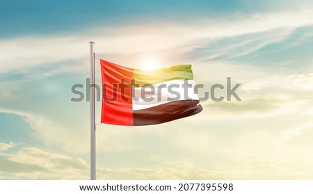 United Arab Emirates national flag waving in beautiful sky.