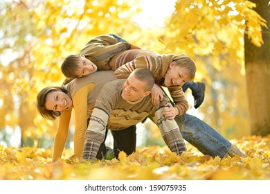 United Family On A Walk During The Fall Of The Leaves In The Park