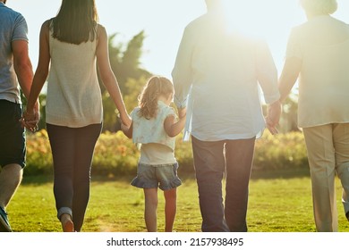 The United Family Is A Strong Family. Rearview Shot Of A Family Going For A Walk Together In The Park.