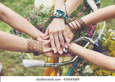 United hands of young females. Stylish hands of girlfriends in boho hippie bracelets near bicycle handlebar, top view. Togetherness and support, youth fashion and active lesiure. Women friendship - Shutterstock ID 459695089